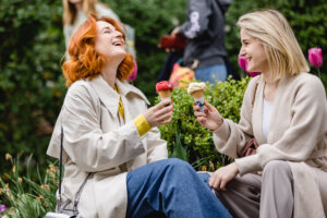 Zwei Frauen essen Eis und lachen.