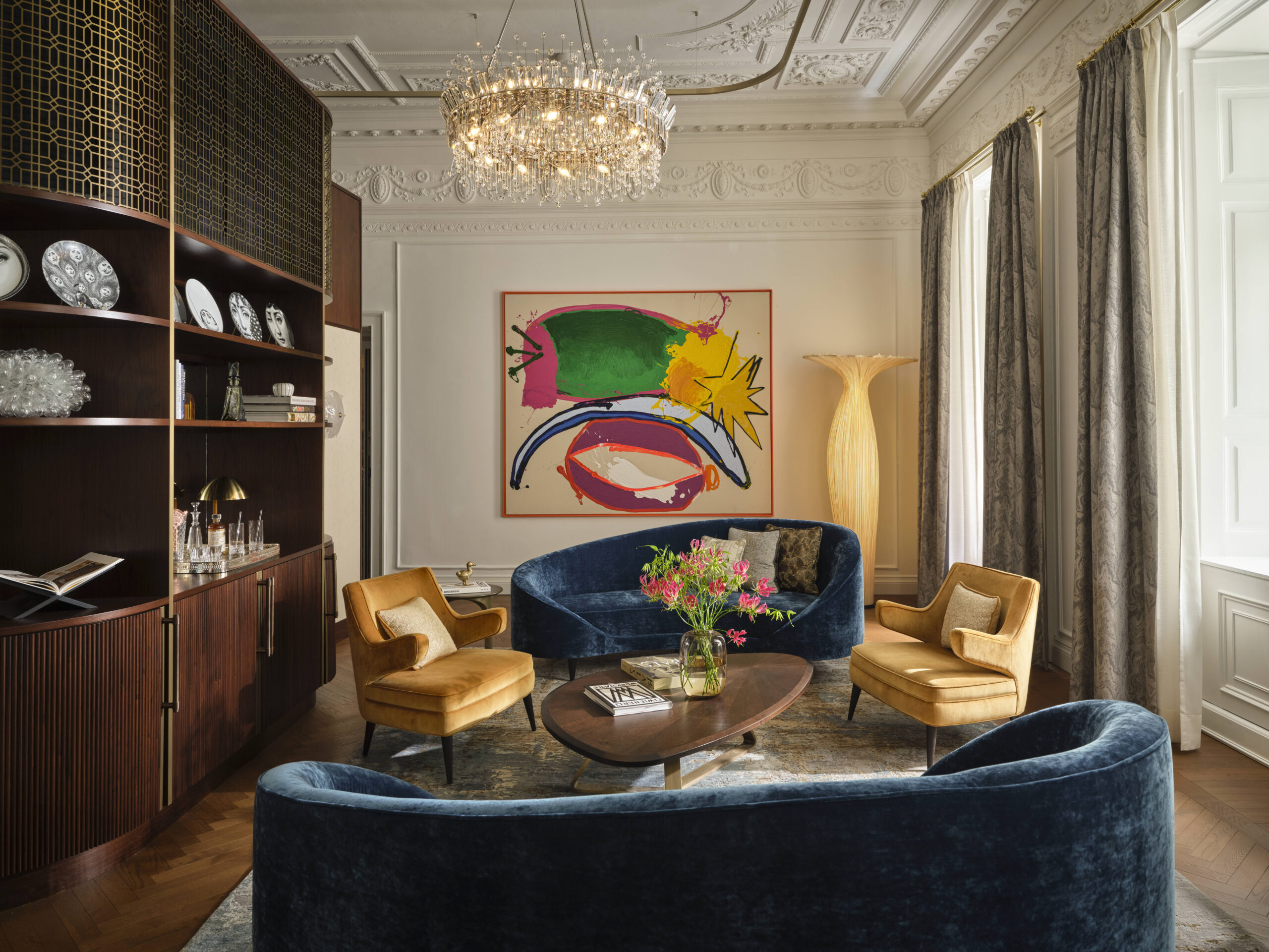 Eine Suite im Hotel Rosewood Vienna. Blaue Couches und gelbe Sessel laden zum Verweilen ein.