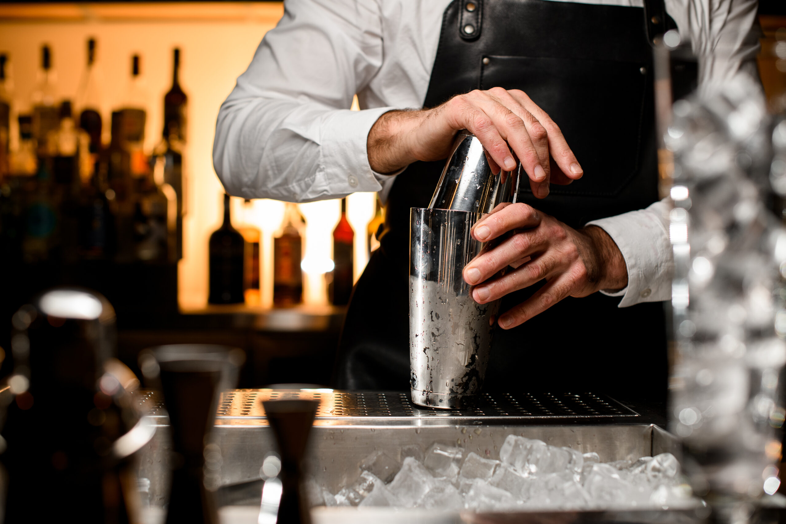 Person an der Bar verwendet Shaker © MaximFesenko iStock Getty Images Plus