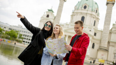 Junge Touristen mit Karte von Wien vor Karlskirche.