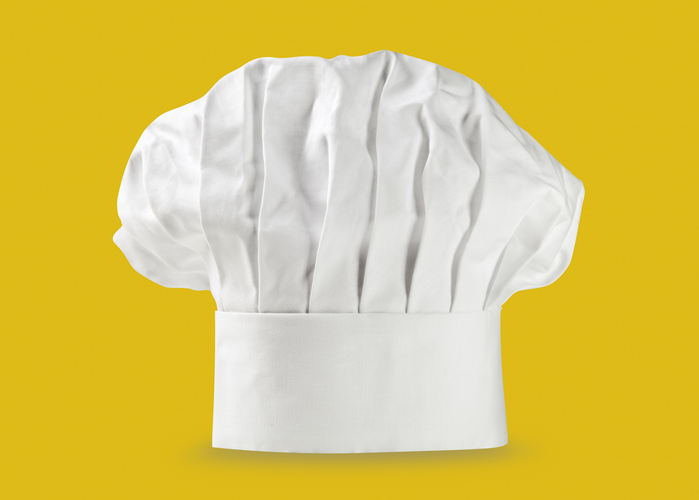 Ein Chef-Hut vor gelben Hintergrund.