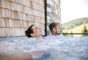 Zwei Menschen sitzen im Whirlpool und entspannen.