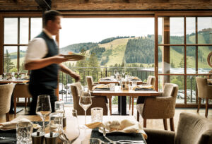 Ein Kellner trägt Teller durchs Restaurant.