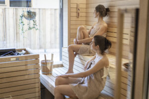 Zwei Frauen sitzen in einer Sauna.