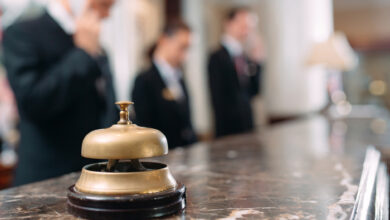 Eine Glocke steht im Vorderrund, ein Hotel Rezeptionsschalter im Hintergrund.