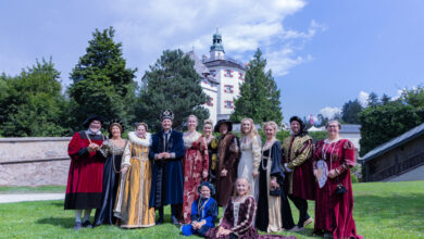 Eine verkleidete Personengruppe steht vor einem Schloss.