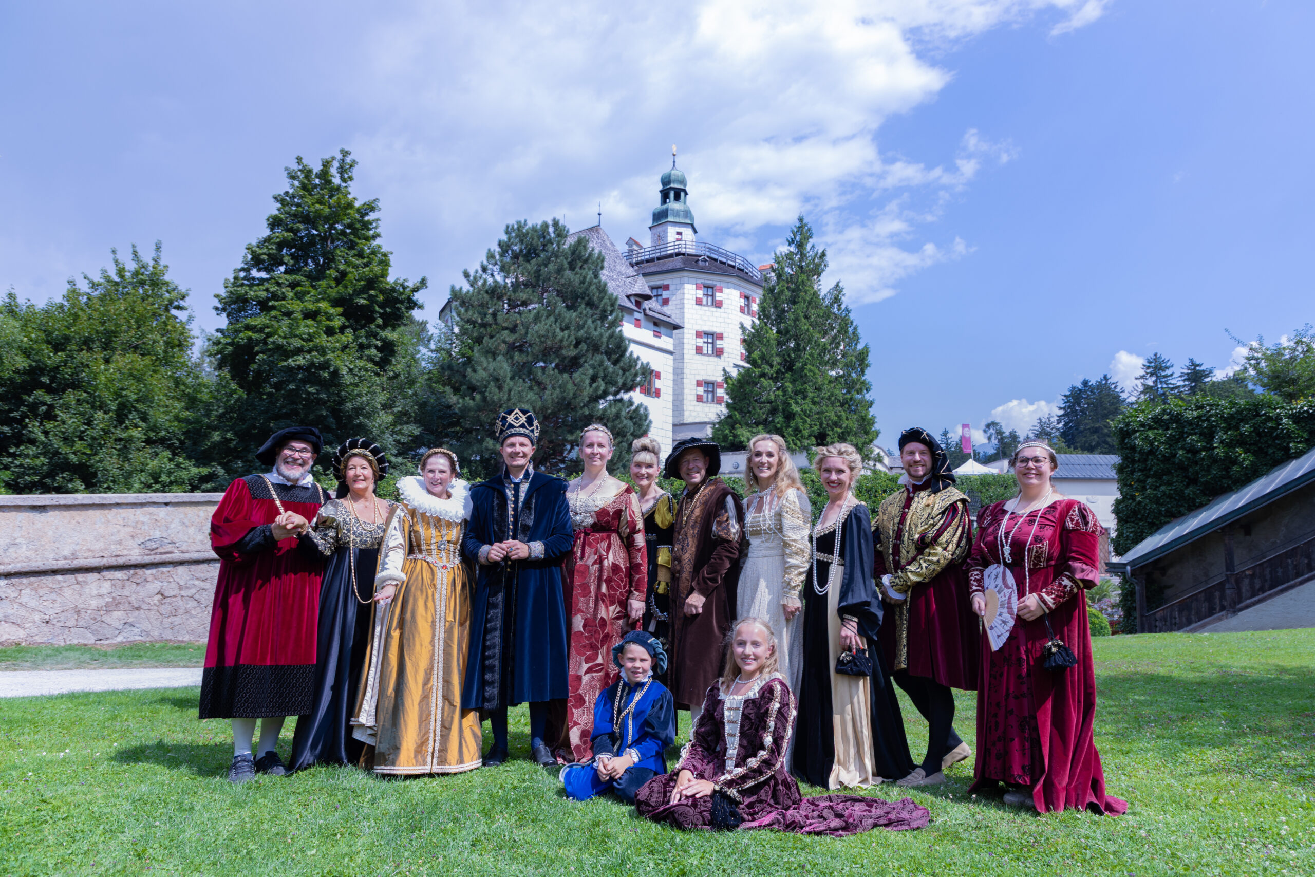 Eine verkleidete Personengruppe steht vor einem Schloss.