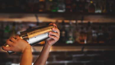 Symbolbild Person an der Bar mit Cocktailshaker © semenovp iStock Getty Images Plus