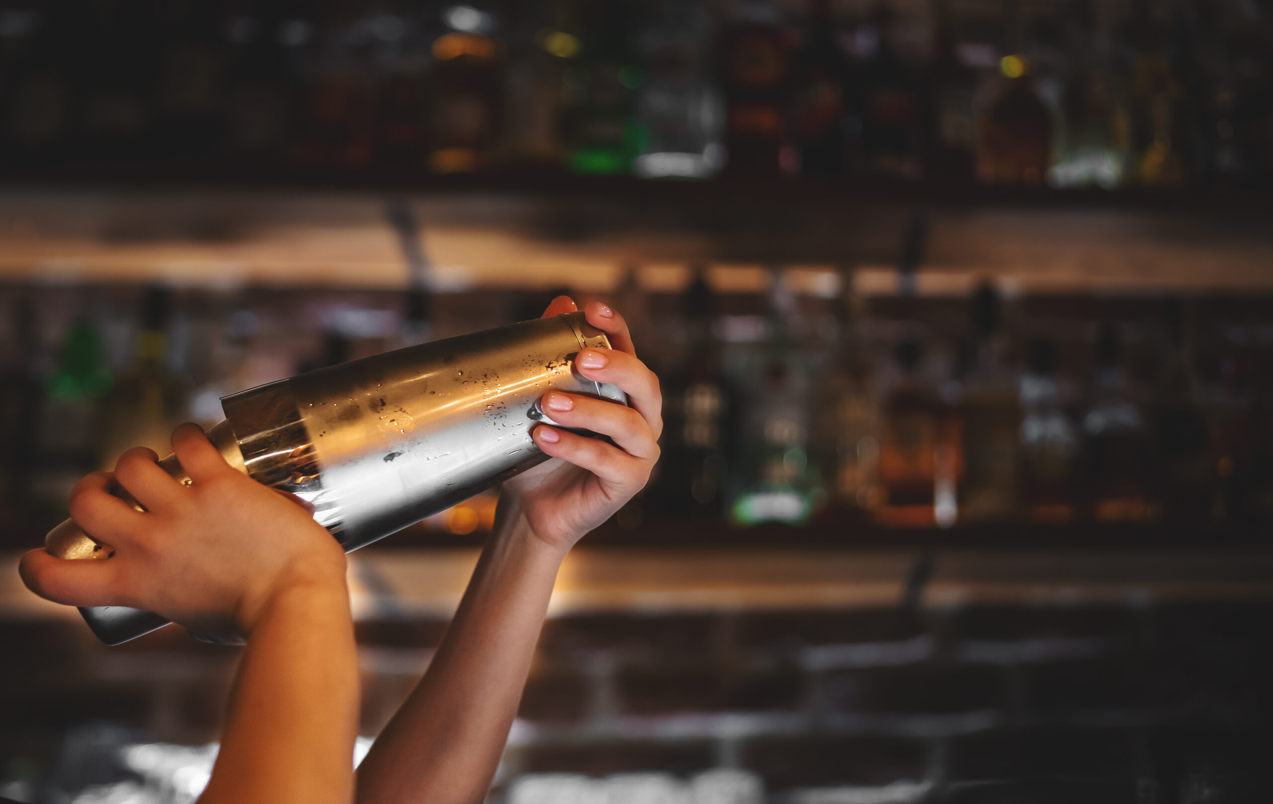 Symbolbild Person an der Bar mit Cocktailshaker © semenovp iStock Getty Images Plus