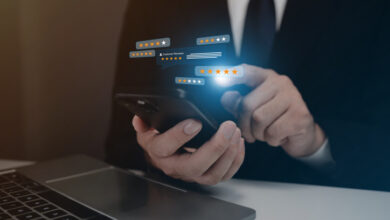 Ein Mann hält ein Handy in der Hand und zeigt auf einen Bildschirm mit einer Reihe von Sternen. Wie schafft man mehr Transparenz für Online-Bewertungen?